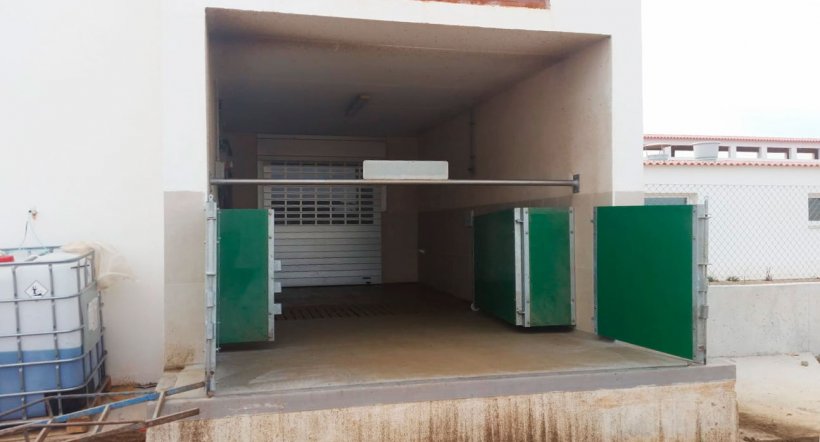 Punto di carico semi-chiuso con porte e sbarre orizzontali per separare fisicamente la zona pulita-zona sporca. Cortesia Agropecuaria Los Girasoles, Spagna.